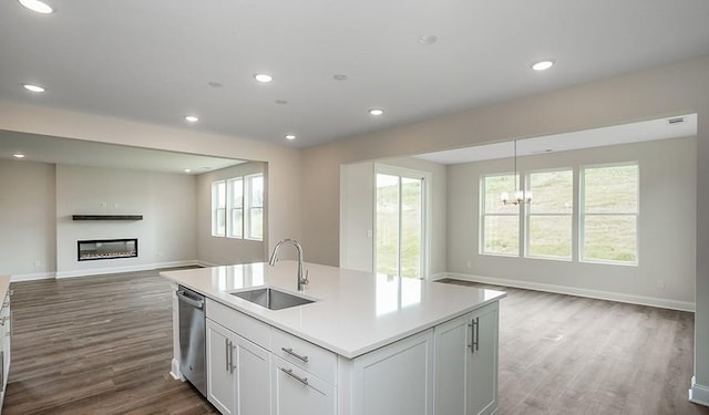 kitchen featuring dishwasher, white cabinetry, hardwood / wood-style flooring, and sink