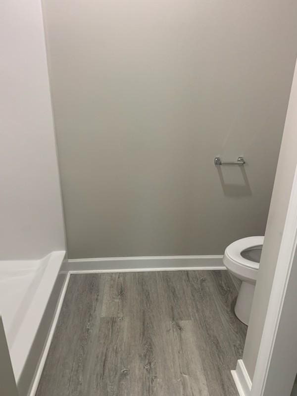 bathroom with toilet and hardwood / wood-style floors