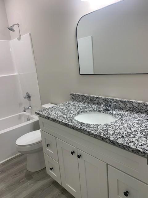 full bathroom featuring vanity, wood-type flooring, shower / washtub combination, and toilet