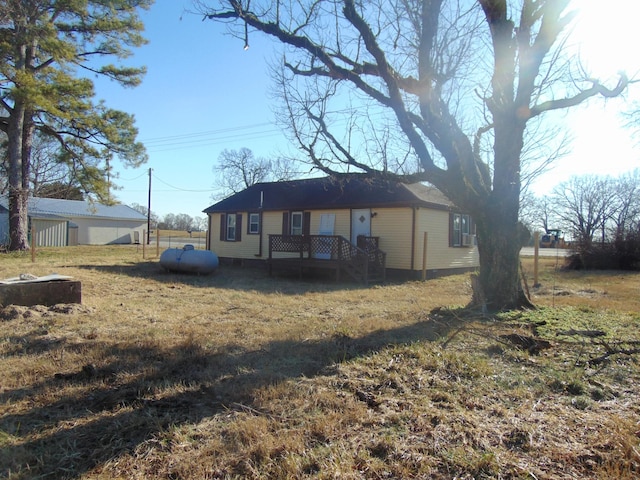 rear view of property featuring a deck and a lawn