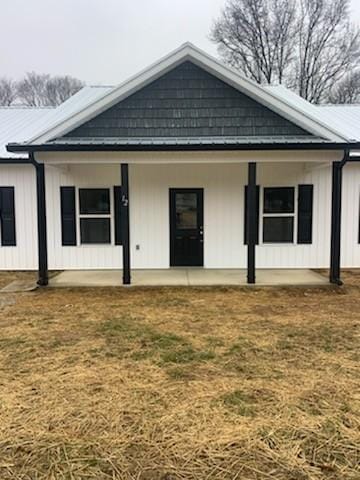 rear view of house featuring a lawn