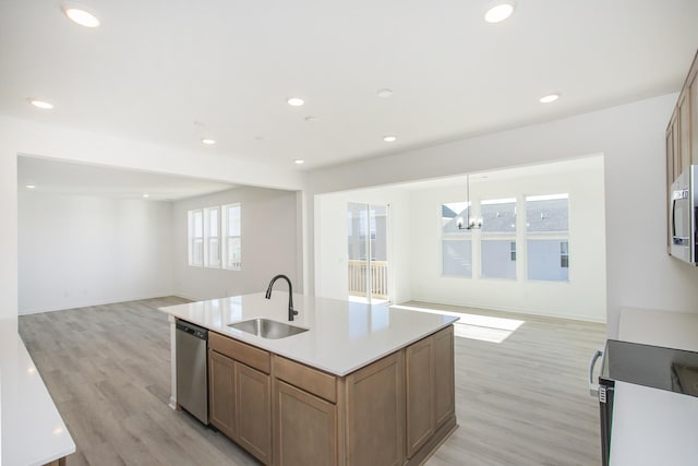 kitchen featuring light hardwood / wood-style floors, stainless steel appliances, a kitchen island with sink, and sink