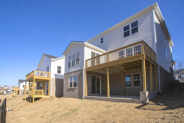 back of property featuring a deck and a patio