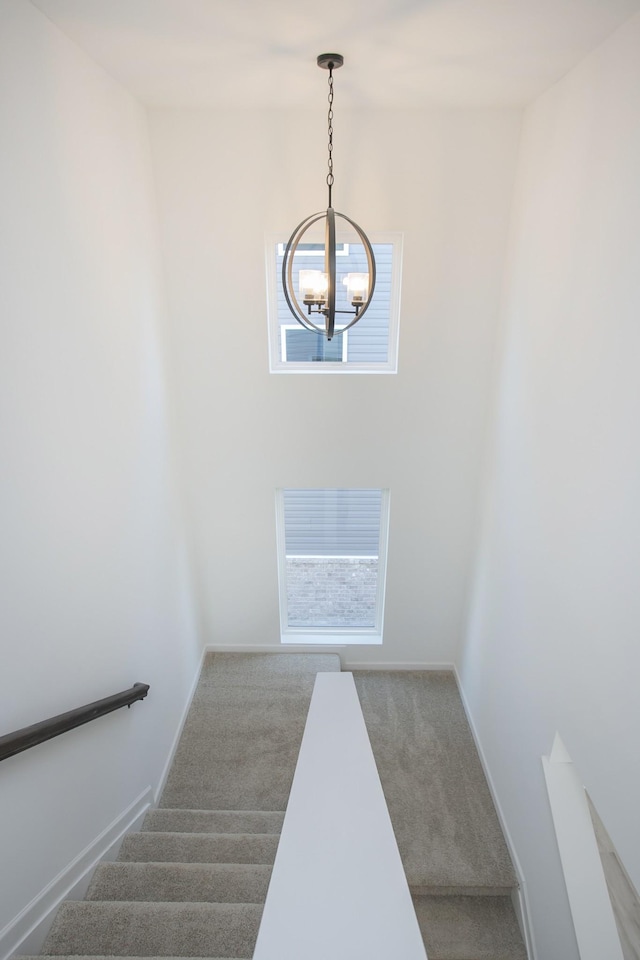 stairs featuring a chandelier and carpet floors