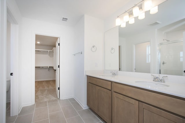 bathroom featuring vanity, tile patterned floors, a shower with door, and toilet