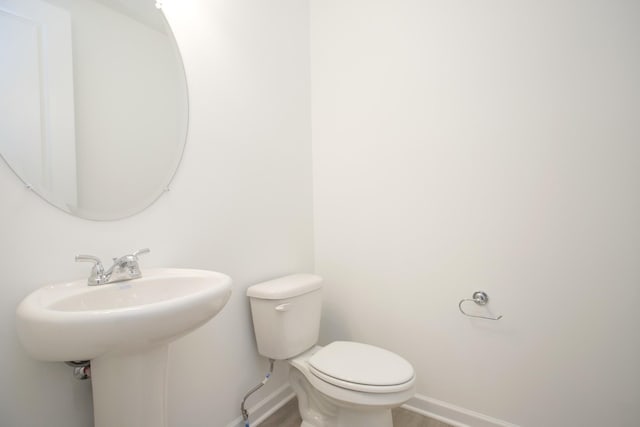 bathroom featuring sink, hardwood / wood-style floors, and toilet