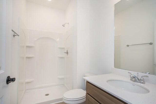 bathroom featuring a shower, vanity, and toilet