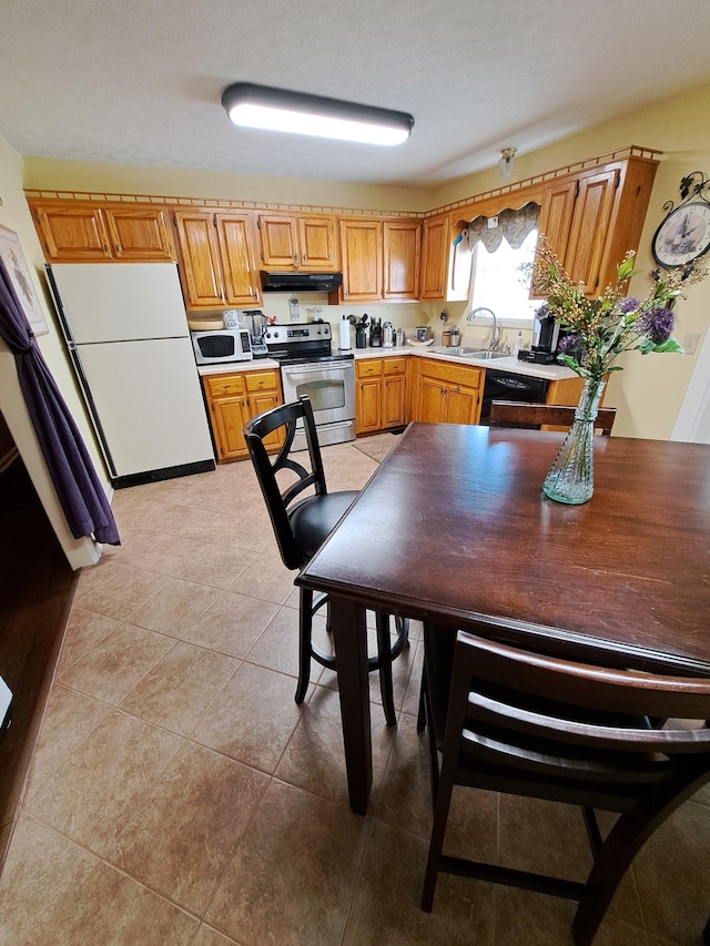 kitchen with white fridge, sink, light tile patterned floors, and electric stove