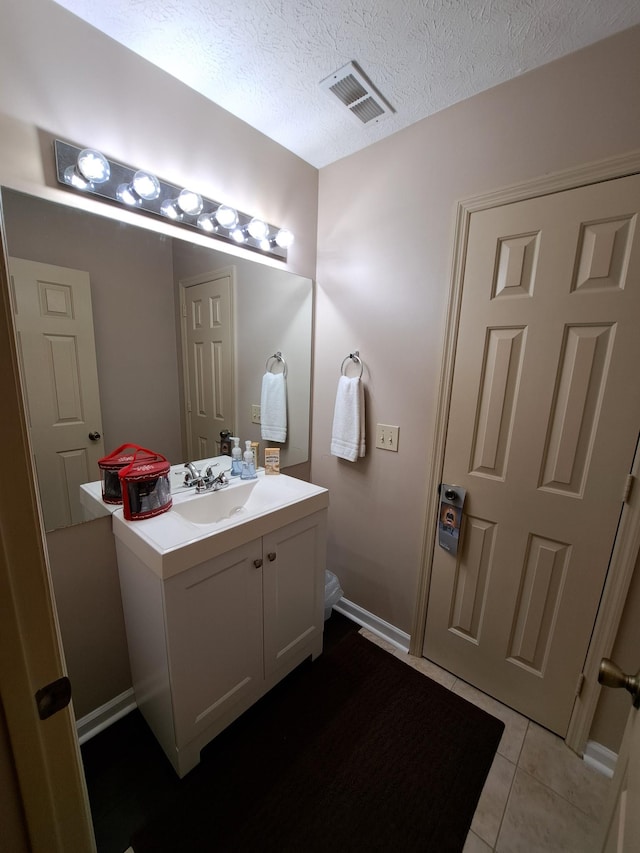 bathroom featuring tile patterned flooring, vanity, and a textured ceiling