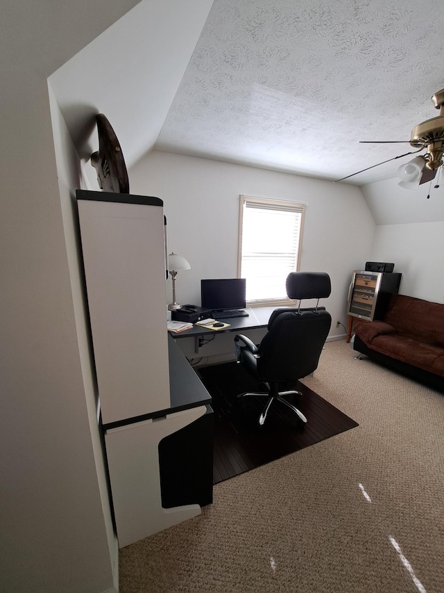 carpeted office with ceiling fan, lofted ceiling, and a textured ceiling