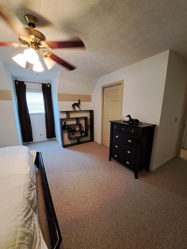 bedroom featuring vaulted ceiling, carpet, ceiling fan, and a textured ceiling