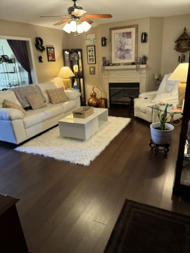 living room featuring ceiling fan and dark hardwood / wood-style flooring