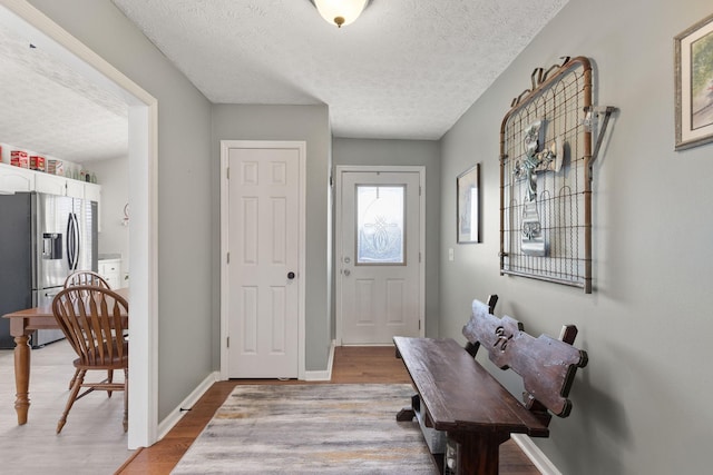 foyer with a textured ceiling and light wood-type flooring