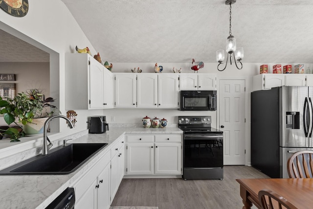 kitchen with white cabinetry, decorative light fixtures, sink, and black appliances