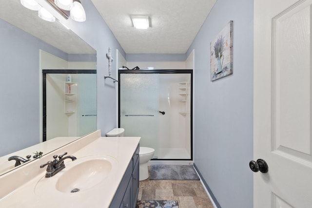 bathroom with vanity, an enclosed shower, a textured ceiling, and toilet