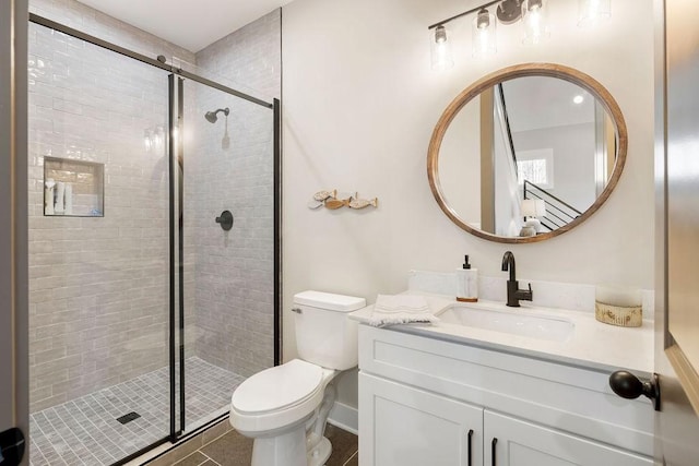 bathroom with a shower with door, vanity, tile patterned flooring, and toilet