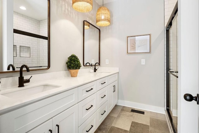 bathroom featuring a shower with door and vanity