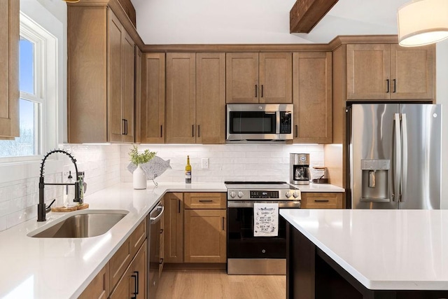 kitchen featuring sink, tasteful backsplash, light wood-type flooring, appliances with stainless steel finishes, and beamed ceiling