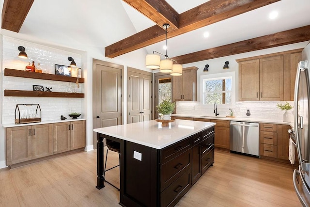 kitchen with light hardwood / wood-style floors, stainless steel appliances, a center island, and sink