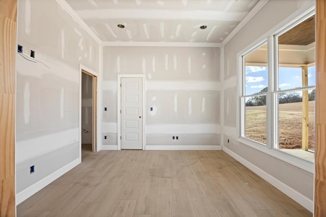 empty room featuring crown molding and light hardwood / wood-style floors