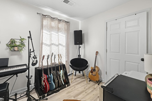 exercise room with light hardwood / wood-style floors