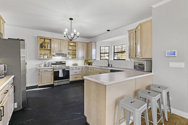 kitchen featuring appliances with stainless steel finishes, decorative light fixtures, light brown cabinets, and kitchen peninsula