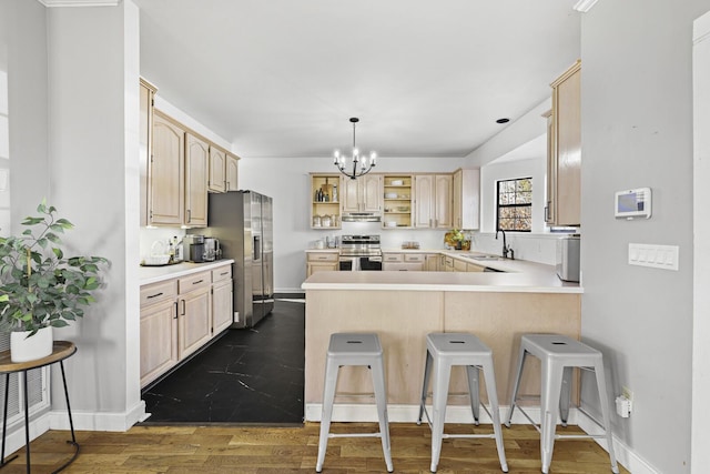 kitchen with light brown cabinetry, sink, a breakfast bar area, kitchen peninsula, and stainless steel appliances