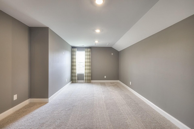 bonus room featuring vaulted ceiling and light colored carpet