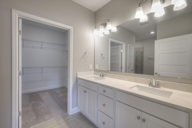 bathroom featuring a shower with door and vanity