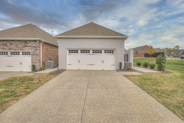 view of side of property with a yard, a garage, and central air condition unit