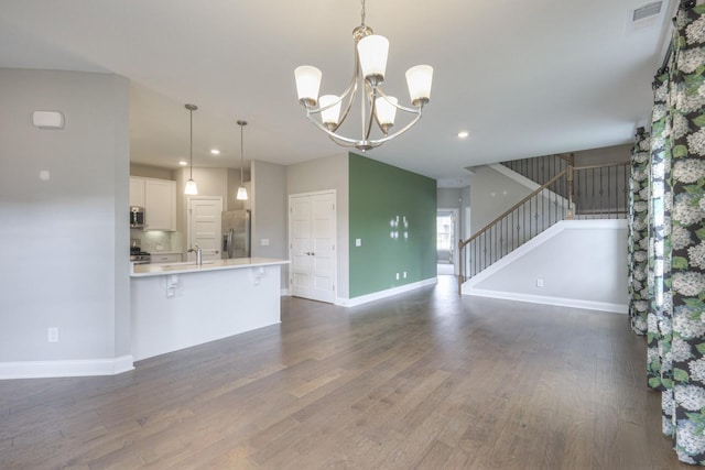 kitchen with pendant lighting, sink, a breakfast bar, appliances with stainless steel finishes, and white cabinets