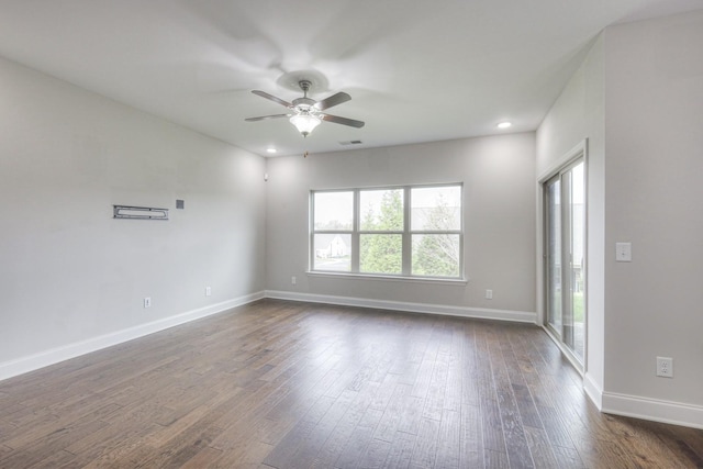 spare room with dark wood-type flooring, ceiling fan, and plenty of natural light