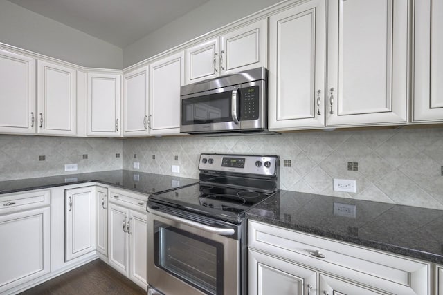 kitchen with white cabinetry, decorative backsplash, stainless steel appliances, and dark stone countertops