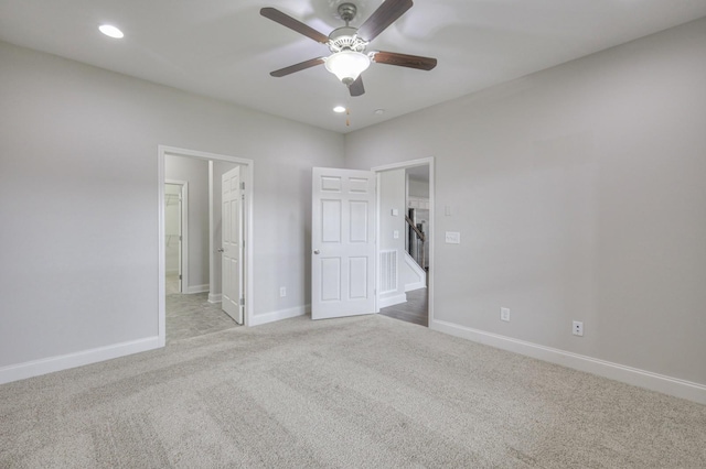 unfurnished bedroom with connected bathroom, light colored carpet, and ceiling fan