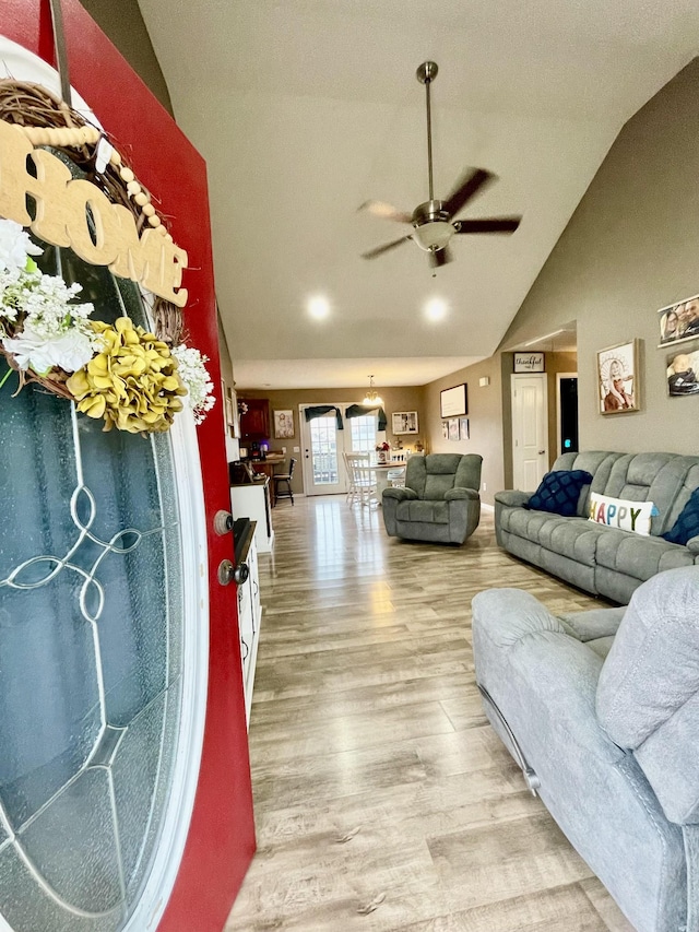 living room with hardwood / wood-style flooring, vaulted ceiling, and ceiling fan