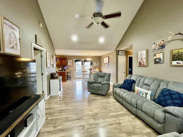 living room featuring ceiling fan, high vaulted ceiling, and light hardwood / wood-style flooring