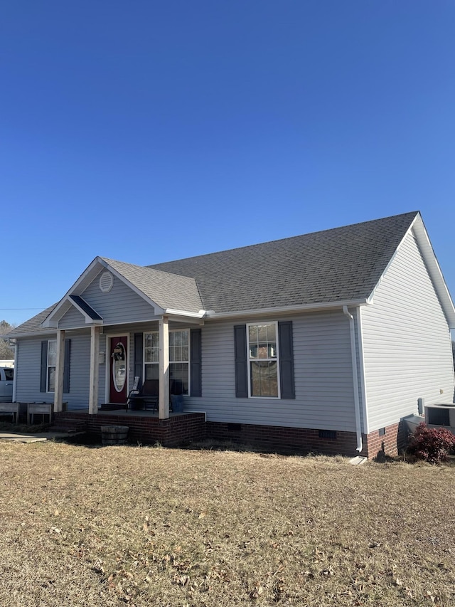 ranch-style home featuring covered porch and a front yard