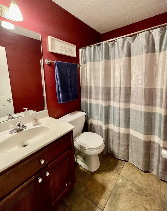 bathroom featuring vanity, toilet, and a textured ceiling