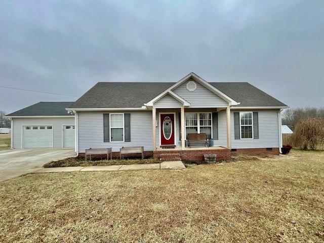 ranch-style home featuring a garage, covered porch, and a front yard