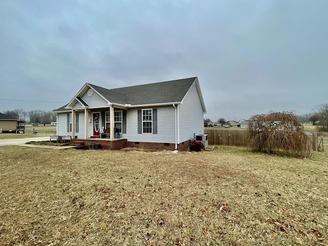 view of front of house featuring a front yard, central AC unit, and covered porch