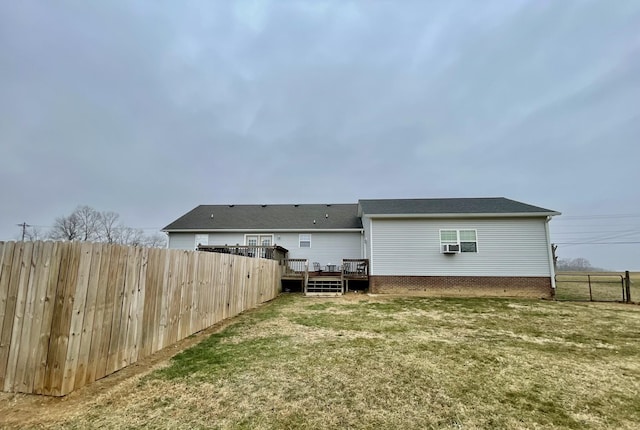 back of house featuring a deck and a lawn