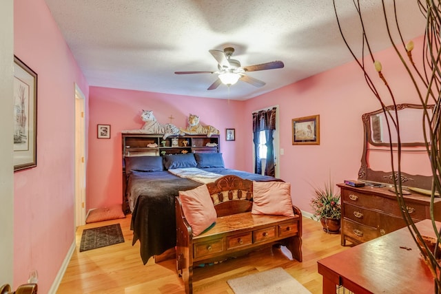 bedroom featuring a textured ceiling, ceiling fan, and light hardwood / wood-style floors