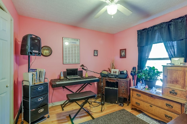 home office featuring ceiling fan, wood-type flooring, and a textured ceiling