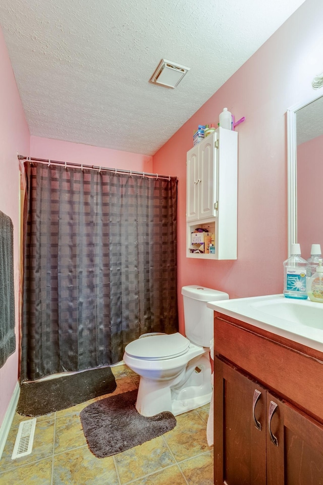 bathroom with vanity, a textured ceiling, and toilet