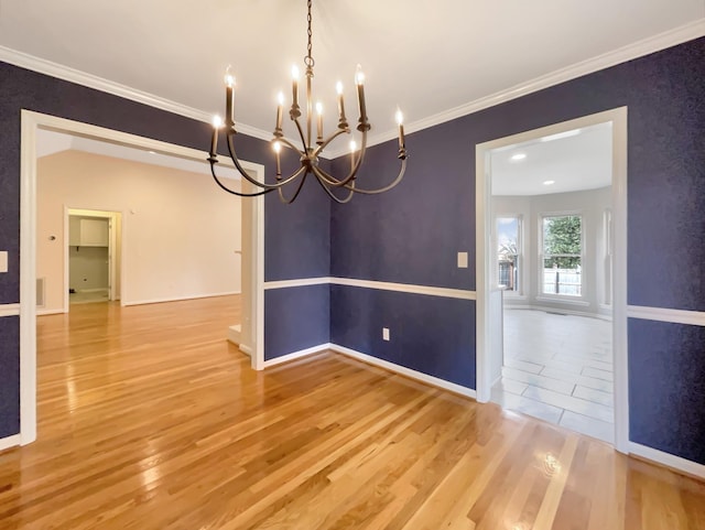 unfurnished dining area with crown molding, hardwood / wood-style flooring, and a chandelier