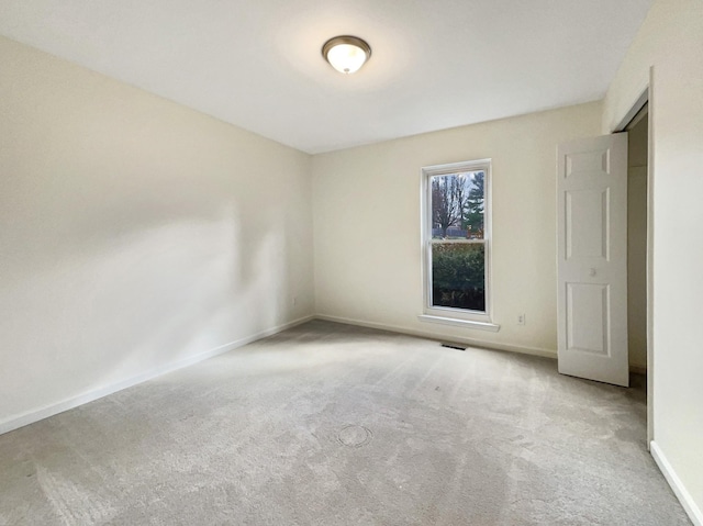 spare room featuring light colored carpet