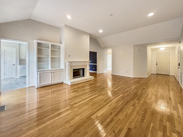 unfurnished living room featuring lofted ceiling and light hardwood / wood-style floors