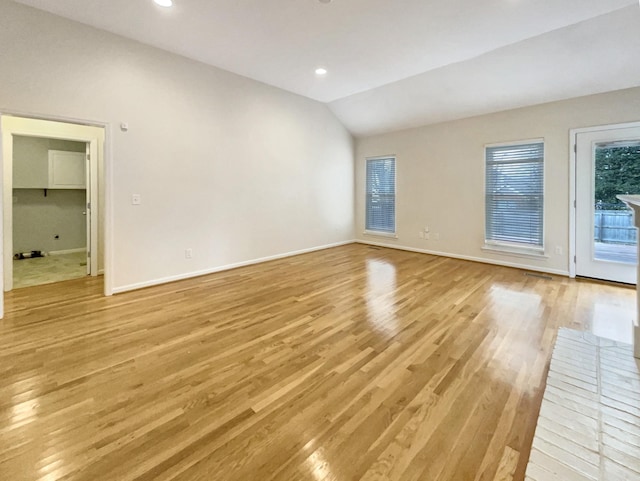 empty room featuring vaulted ceiling and light wood-type flooring