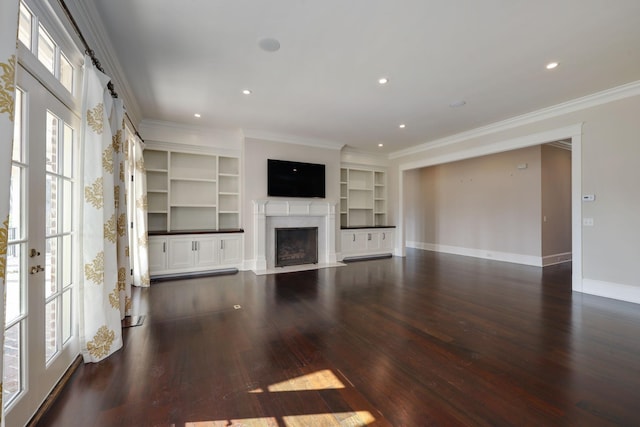 unfurnished living room featuring crown molding, plenty of natural light, built in features, and french doors