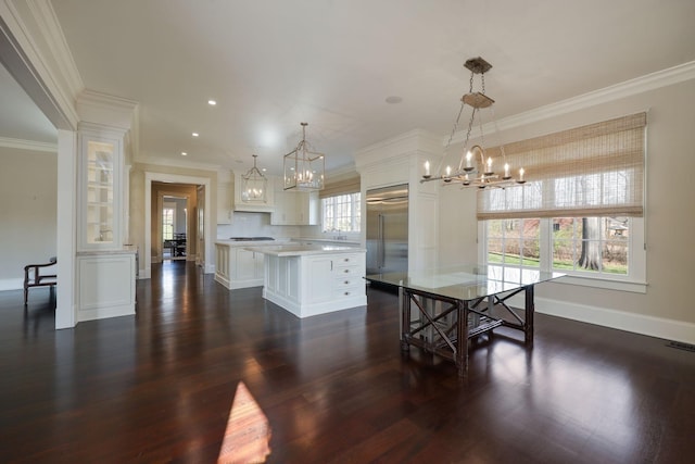 dining area with ornamental molding, dark hardwood / wood-style floors, and a chandelier